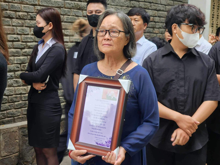 Bà Nguyễn Thị Tuyết, ngụ ở Bình Dương, ôm trên tay khung ảnh có hình Tổng Bí thư Nguyễn Phú Trọng cùng bài thơ do mình sáng tác khi đi viếng tại Hội trường Thống Nhất.