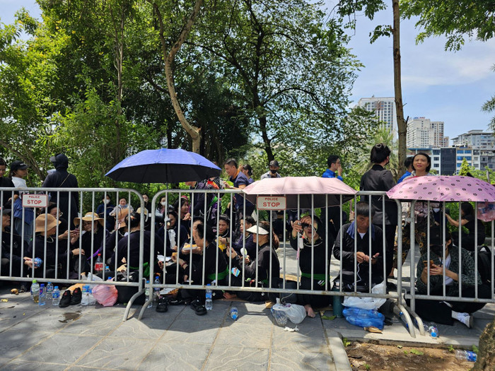 Người dân xếp hàng ngồi chờ đến giờ viếng.