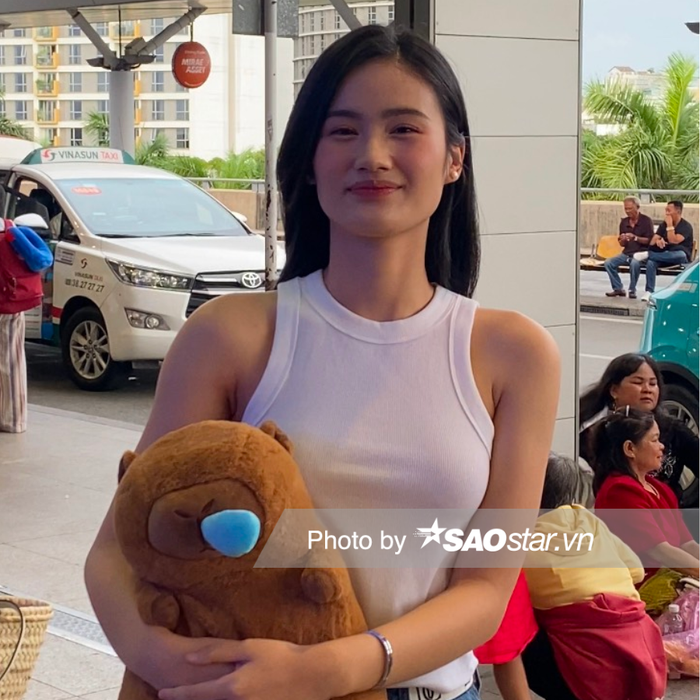 Hoa hậu Ý Nhi xuất hiện tươi tắn, rạng rỡ và được một lượng nhỏ người hâm mộ đến đưa tiễn. Cô diện trang phục đơn giản nhưng vẫn tôn lên được vóc dáng chuẩn. Hoa hậu Ý Nhi kết hợp giữa áo ba lỗ trắng, ôm sát cùng chân váy dài jean tạo cảm giác thoải mái, năng động.