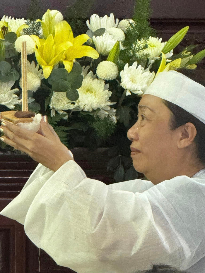 Người vợ đội khăn tang trong đám tang của nghệ sĩ Lê Hùng.