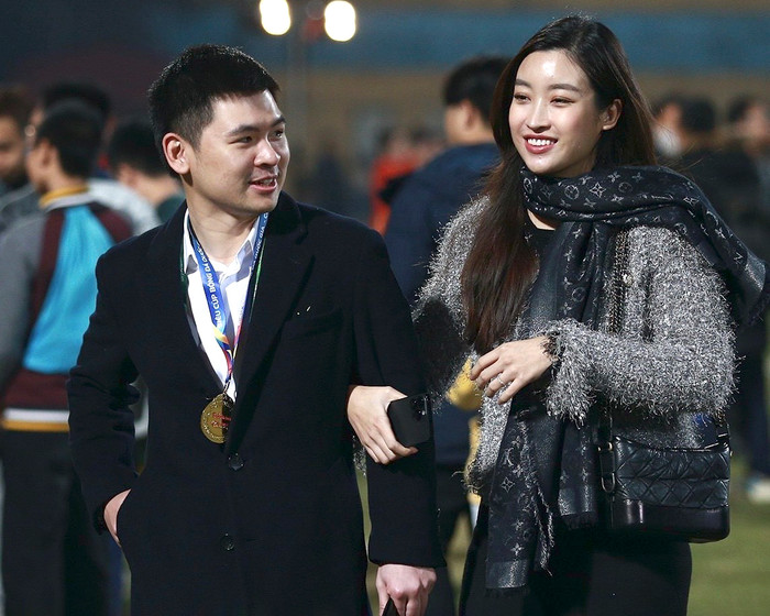 Trong một khoảnh khắc khác, Đỗ Mỹ Linh diện trang phục kín đáo, chất liệu dày dặn ấm áp, song hành cùng chồng đến sân bóng. Cô cũng chọn mẫu túi xách đeo chéo trị giá 150 triệu đồng để làm món phụ kiện tô điểm cho tổng thể.