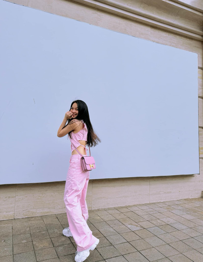 Chiếc áo crop top cắt xẻ tinh tế ở phần eo và lưng, tôn lên vòng eo con kiến của Hiền Thục. Thiết kế này không chỉ tạo nên điểm nhấn gợi cảm mà còn giúp cô nàng tăng thêm phần duyên dáng. Màu hồng pastel nhẹ nhàng, vừa đủ nổi bật nhưng không quá chói mắt, rất phù hợp với làn da trắng mịn của Hiền Thục.