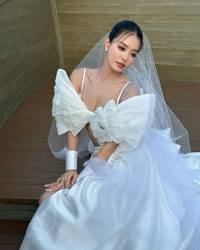 Á hậu Khánh Linh thả dáng trong thiết kế váy cưới. Trang phục này được thực hiện theo form dáng hiện đại, phần trên là mẫu áo hai dây giúp nàng hậu khoe trọn bờ vai 'móc áo' quyến rũ. Á hậu Khánh Linh còn khéo léo kết hợp với phong cách trang điểm nhẹ nhàng, tạo điểm nhấn bằng đường đính đã quanh vùng mắt. Với hướng đi này, Á hậu 1 - Miss Grand Vietnam sáng bừng nhan sắc trong veo tựa tiên tỷ nhưng vẫn đảm bảo độ lộng lẫy, ấn tượng. Hiện tại, Á hậu Khánh Linh đang là mảnh ghép đặc biệt của chương trình hẹn hò đình đám Đảo Thiên Đường.