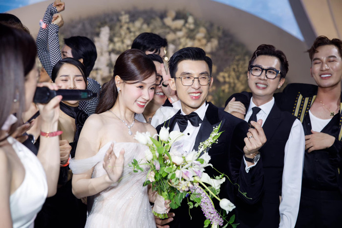 Midu và chồng thiếu gia vui vẻ tạo dáng chụp hình trong đám cưới. Ảnh: FBNV