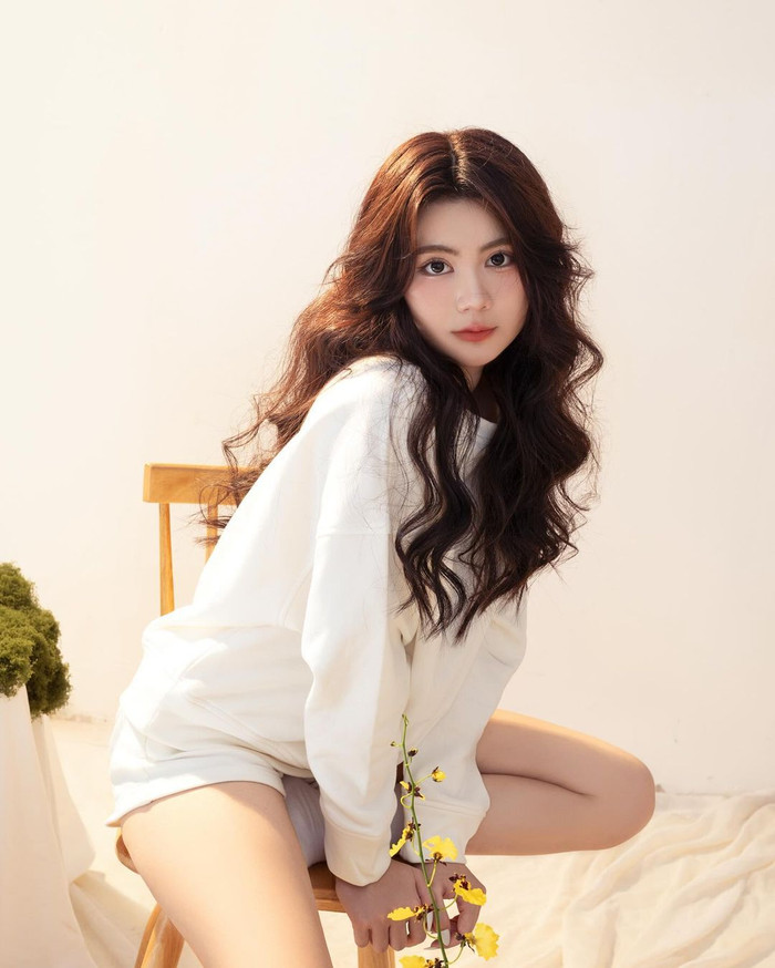 Nét thuần phác và trong trẻo tuổi trăng rằm được Hạt Dẻ thể hiện qua bảng màu trang phục. Nàng út diện áo sweater tay dài chần bông phối cùng quần kaki phom ngắn.  