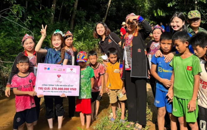 Hoà Minzy vui vẻ chụp hình cùng mọi người sinh sống ở khu vực xây cầu. Ảnh: FBNV