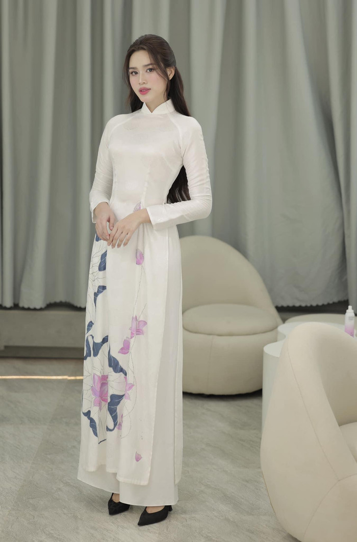 Đỗ Thị Hà lại nền nã trong tà áo dài trắng, điểm xuyến bằng hoạ tiết hoa sen. Nàng hậu còn kết hợp với kiểu tóc uốn nhẹ nhàng, mềm mại cùng phong cách trang điểm trong veo, sáng bừng nhan sắc tiên tỷ.