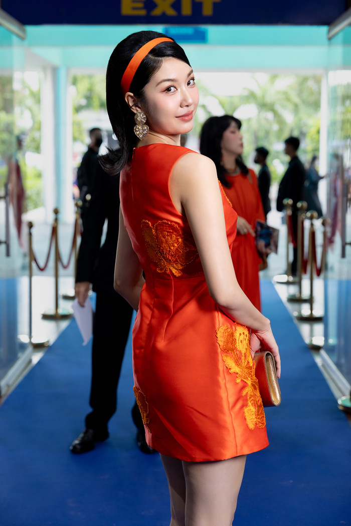 Á hậu Thúy Vân khéo khoe đôi chân thon gọn cùng thiết kế đầm ngắn không tay. Cô được khen ngợi đẹp cổ điển khi chọn cài tóc đồng màu trang phục. 