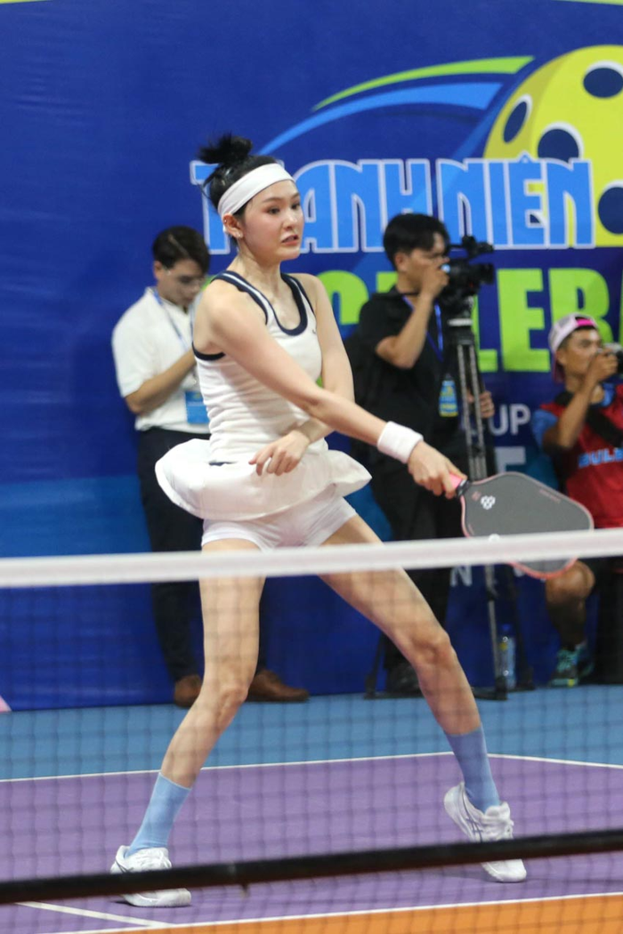 Hiền Hồ chuyển từ môn golf thành pickleball trong thời gian qua. Trong giải đấu gần đây, Hiền Hồ chọn mặc áo tanktok viền trắng đen kết hợp cùng váy quần để tránh bị hớ hênh trên sân. Cô còn đeo thêm cài tóc gọn gàng, mang tất xanh cùng giày thể thao trắng sang trọng. 