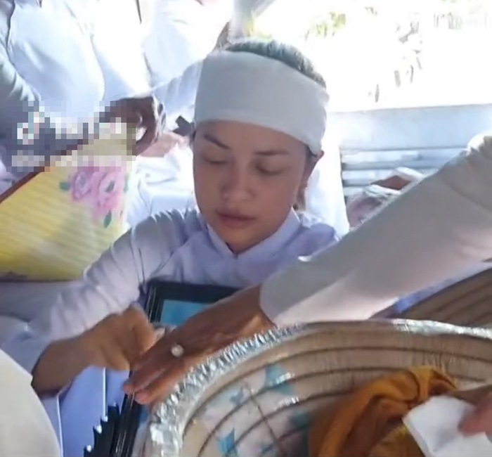 Ngọc Châu tiều tụy, buồn bã ôm di ảnh của mẹ trong ngày đưa linh cữu của bà đi an táng. 