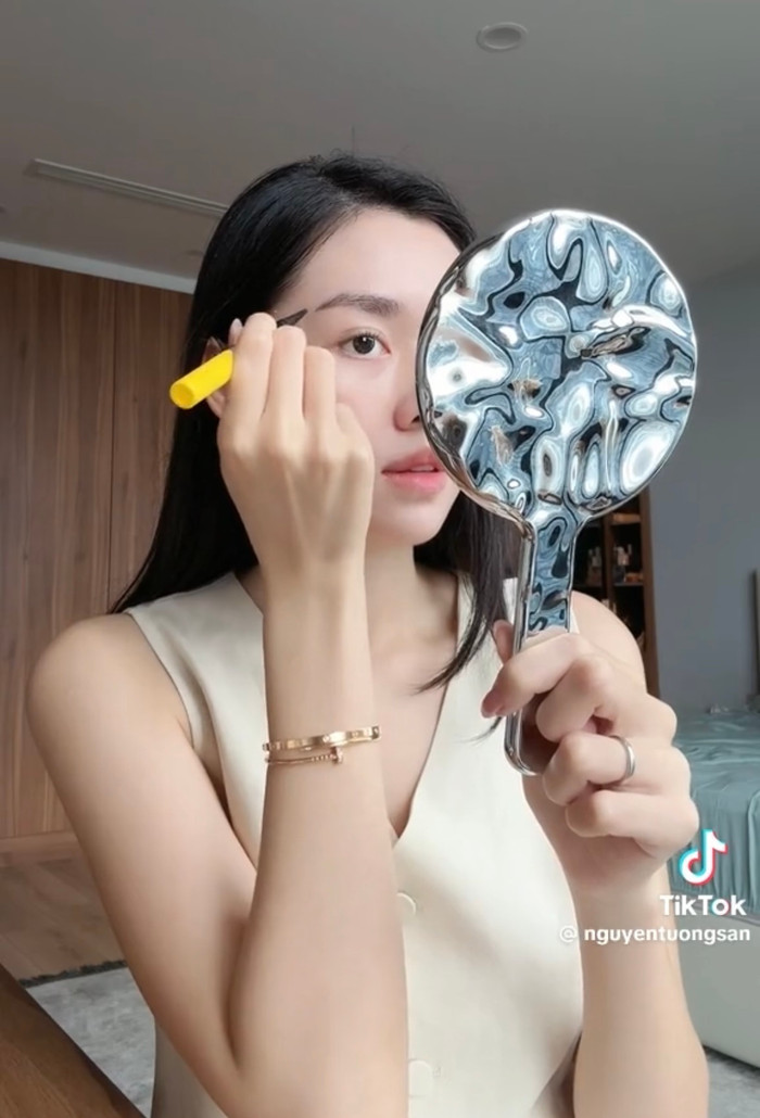 Sau đó, cô nàng sử dụng một lớp phấn phủ giúp lớp kem chống nắng không bị nhờn rít, tạo độ khó chịu trên da. Tường San vẽ thêm lông mày, tô má hồng để gương mặt trở nên hài hòa.
