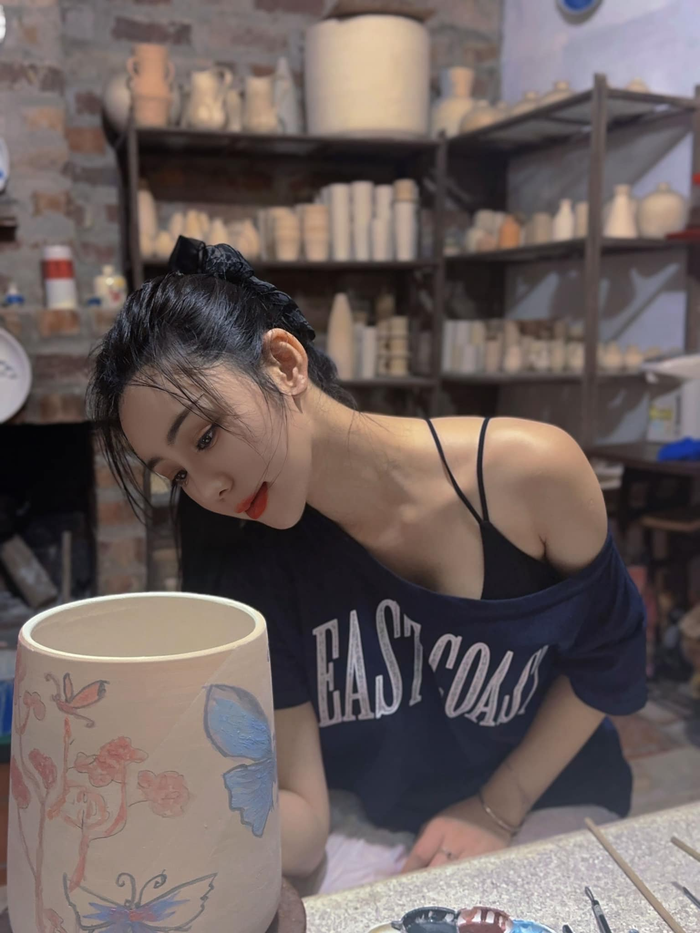 Dù đi làm gốm, Quỳnh Kool cũng không quên để lộ bờ vai thanh mảnh với áo thun cổ rộng. 