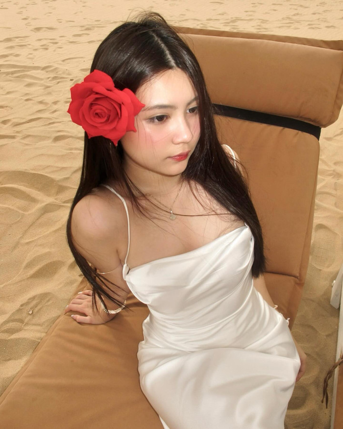 Mai Thảo Ngọc cài thêm hoa đỏ trên tóc làm tăng thêm độ đằm thắm của chiếc váy lụa. Cô bé được khen ra dáng thiếu nữ xinh đẹp ở tuổi trăng tròn. 