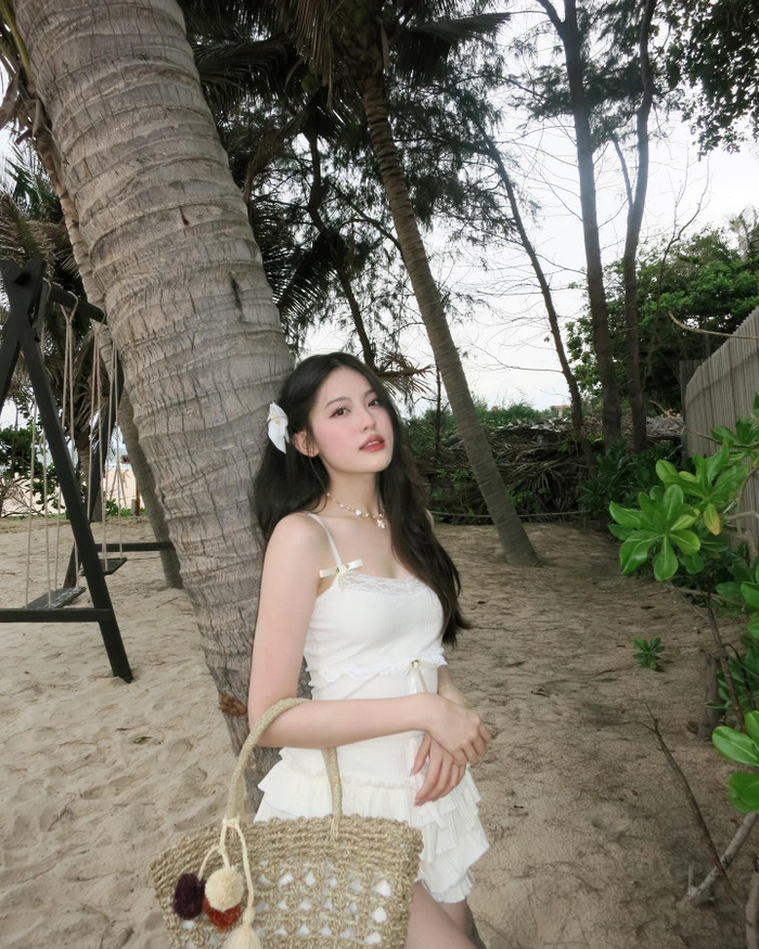 Khi đi biển, người đẹp 21 tuổi khoe làn da trắng ngần với set váy + áo hai dây ngắn vừa thoải mái, vừa tạo cảm giác quyến rũ. 