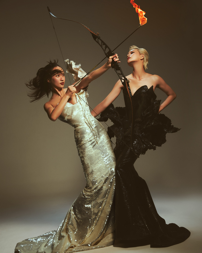 Bộ môn bắn cũng là một trong những phần không thể thiếu tại Olympic. Hai người đẹp tạo nên hình ảnh đầy mới mẻ khi mặc váy dạ hội tương phản để tạo dáng bắn cung. 