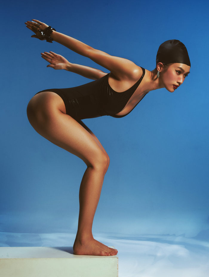 Đầu tiên là bộ môn bơi, người đẹp Vũ Thúy Quỳnh khoe trọn đường cong quyến rũ với mẫu áo tắm một mảnh màu đen trơn. Cô nàng tạo tư thế chuẩn bị xuất phát kết hợp với nền màu xanh dương cùng hiệu ứng nước khiến khung cảnh trở nên nghệ thuật. 