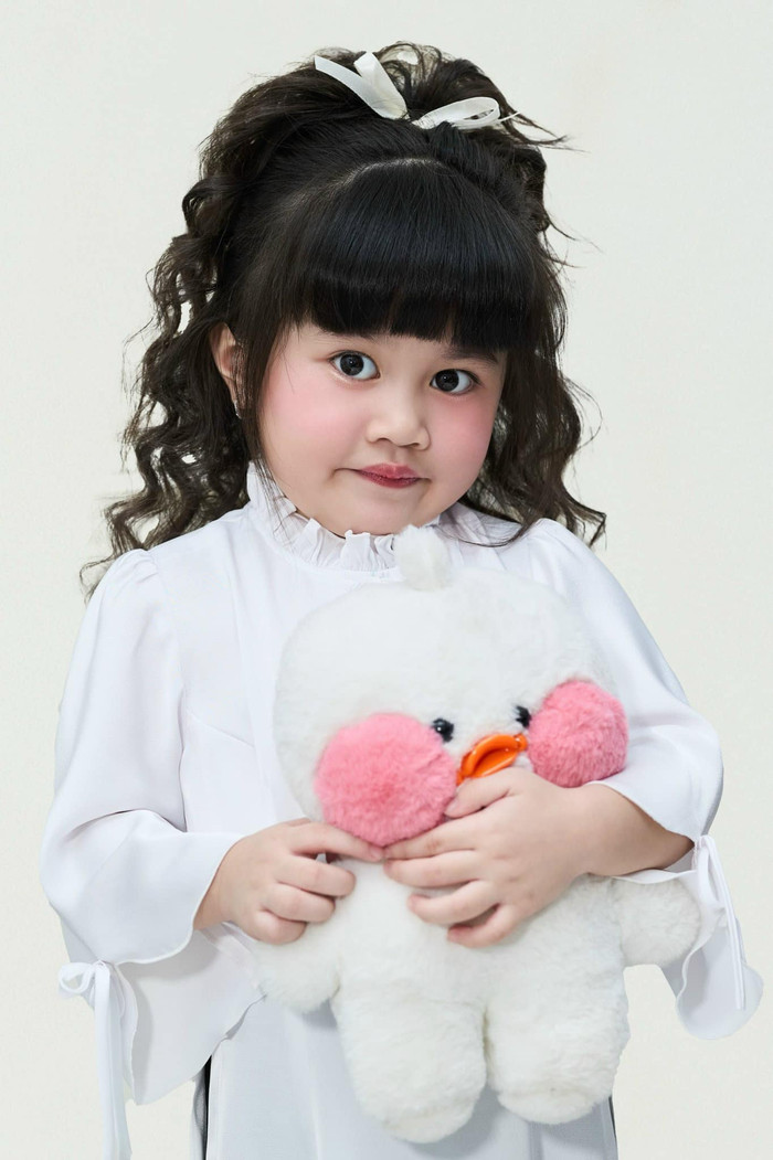 Cô bé có đôi mắt to tròn, khuôn mặt bầu bĩnh.