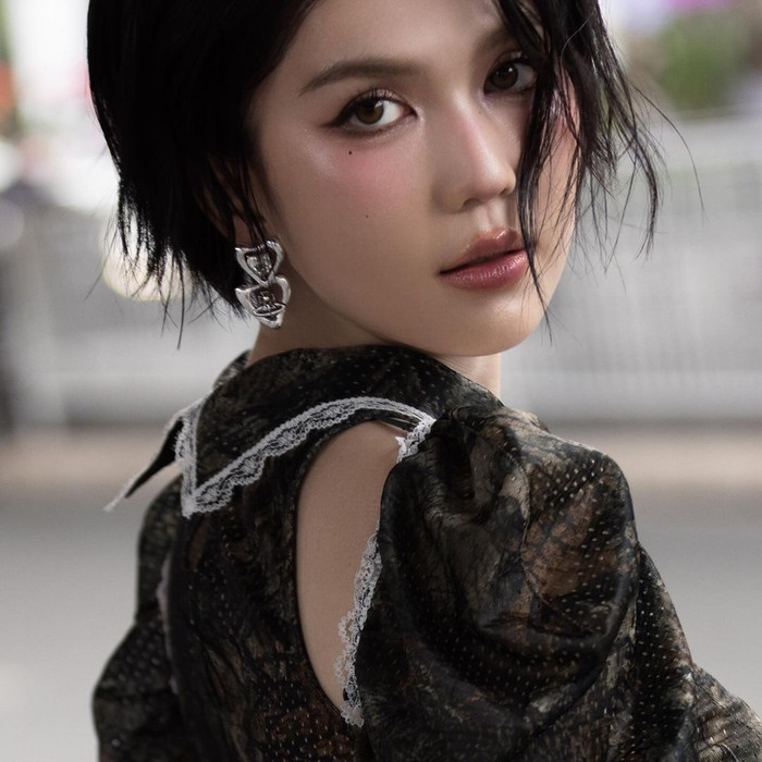 Không đội tóc giả như mọi lần, Ngọc Trinh toát lên tinh thần cá tính, mang đậm tính thời trang với kiểu tóc tém, ôm sát gương mặt. Để tăng thêm phần quyến rũ, nữ người mẫu còn khéo léo tạo độ ướt át cho mái tóc. Ngọc Trinh cũng thay đổi phong cách trang điểm. Không còn là những layout trong trẻo, nhẹ nhàng thường thấy trong những tháng qua, Ngọc Trinh trưng dụng kiểu 'make up' đậm, được tạo khối tỉ mỉ. Điểm nhấn cho lớp trang điểm này còn nằm ở phần phấn mắt tông khói và má hồng lan rộng sang mũi.