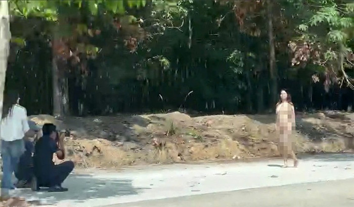 Cô gái khoả thân và tạo dáng để nhóm nam nữ thanh niên chụp hình. Ảnh cắt từ clip