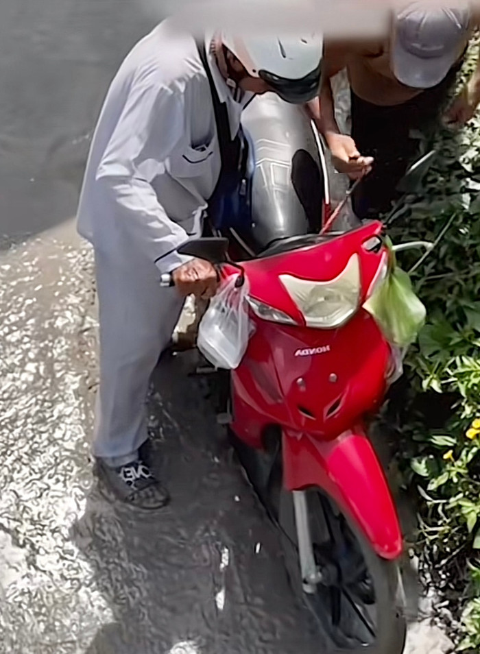 Chứng kiến cảnh tượng này, một thanh niên trong nhóm đã không kìm được sự bức xúc, liền tiến lại gần và rút chìa khóa xe của ông cụ.