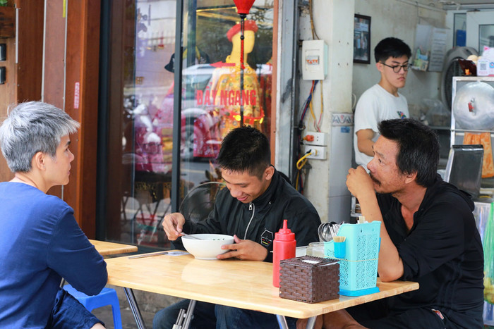 Anh Dũng (góc bên trái) và người bạn ngồi ăn 'phở treo' cùng trò chuyện cùng chị Cát Lệ