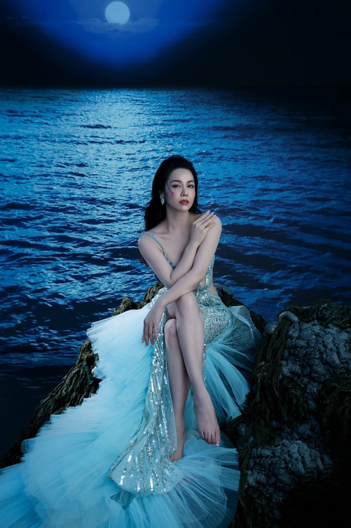 Lớp voan nhẹ nhàng và phần đuôi váy dài giúp tăng thêm phần duyên dáng khiến Nhật Kim Anh trông như một nàng tiên cá giữa biển xanh.