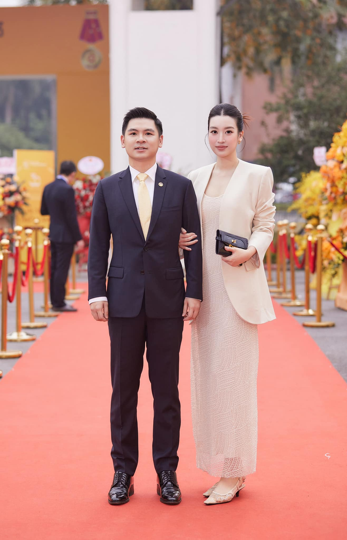 Đỗ Mỹ Linh ghi điểm với trang phục vô cùng sang trọng khi đến sự kiện cùng ông xã. Cô mặc một chiếc đầm vải tuyn dài chấm gót kết hợp blazer vai vuông, không cúc và phối clutch cầm tay đen. Người đẹp búi tóc 'slicked spiky bun' để tăng thêm độ sang chảnh cho tổng thể. 