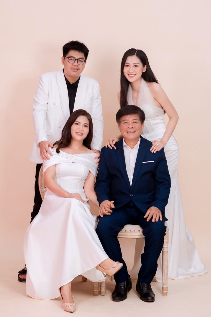 Khung ảnh gia đình hạnh phúc của Hoa hậu Quế Anh bên cạnh bố mẹ và em trai. 