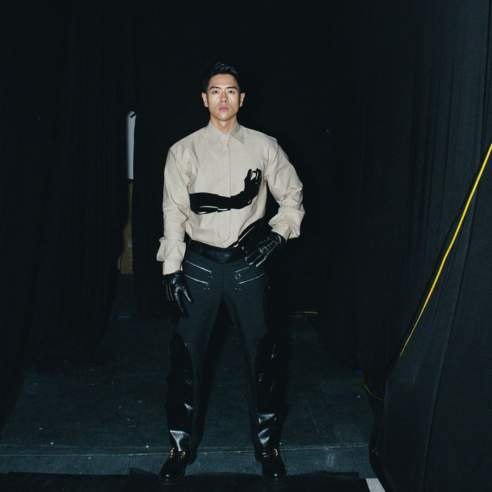 Trong những sự kiện, Michael Trương khá khéo léo trong việc định hình phong cách. Nam người mẫu thường xuất hiện trong hình ảnh lịch lãm nhưng không kém phần ấn tượng. Nam thần 'Đảo Thiên Đường' kết hợp mẫu áo sơ mi cùng chiếc quần phối chất liệu da và kaki. Để thêm phần ấn tượng, hầm hố, Michael Trương còn mang kèm hai món phụ kiện là giày và bao tay da bóng.