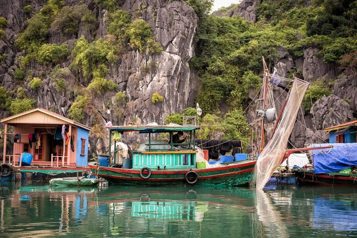 Di chuyển thuyền nan tới cổng làng, bạn sẽ thấy một ngôi làng nổi xuất hiện rất bình dị, đơn sơ, xung quanh được bao phủ bởi núi trùng trùng điệp điệp, thấp thoáng hình ảnh các lán nuôi cá bè dọc theo vách núi lẫn với những chiếc phao nổi xếp hàng thẳng tắp.