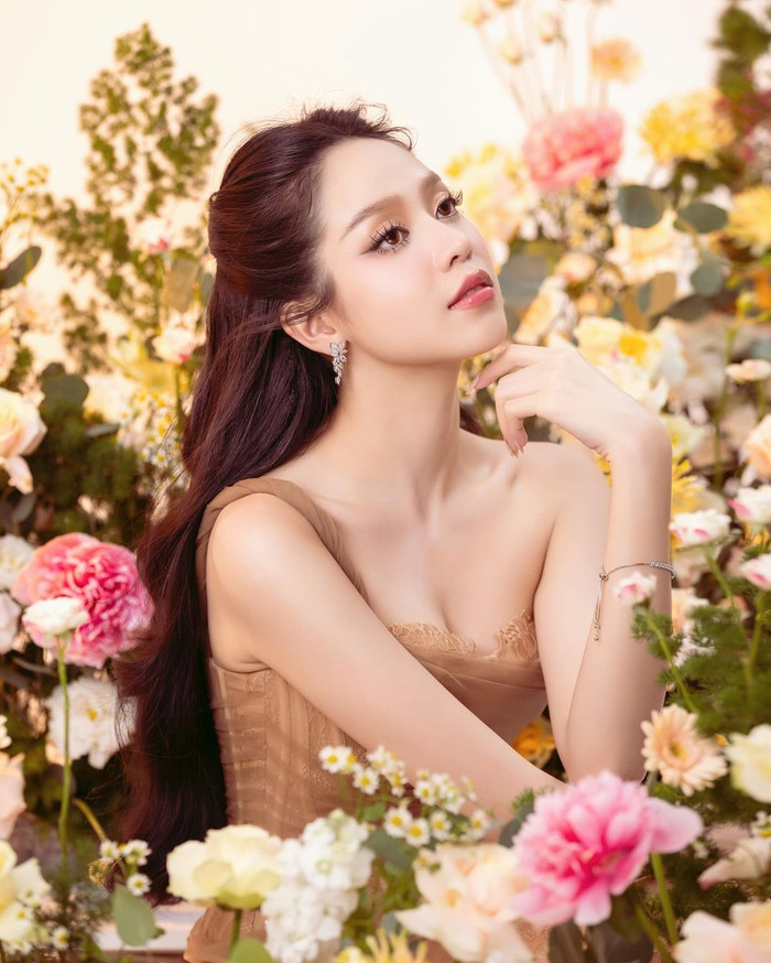Hoa hậu Thanh Thủy khoe sắc rạng rỡ giữa không gian phủ đầy hoa. Trước thềm chinh chiến Miss International 2024, nàng hậu Đà Nẵng thăng hạng sắc vóc lẫn khí chất thấy rõ. Hoa hậu Thanh Thủy ghi điểm với gương mặt tròn đầy, đường nét mềm mại phúc hậu cùng làn da mịn màng, không chút khuyết điểm. Để tôn lên ưu điểm này, đương kim Hoa hậu Việt Nam 'trưng dụng' phong cách trang điểm nhẹ nhàng, chỉ nhấn nhá bằng đôi môi hồng căng bóng.
