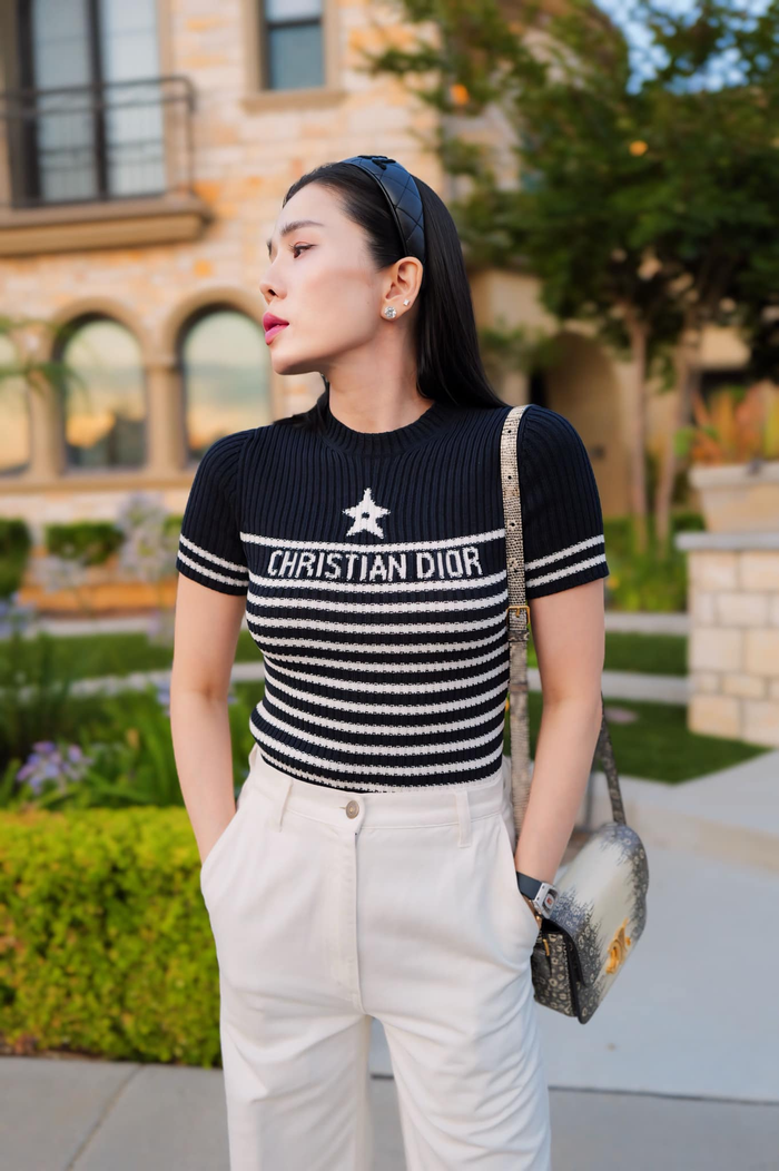 Áo thun sọc ghi rõ chữ Christian Dior có giá trị khoảng 38 triệu được Lệ Quyên kết hợp với quần tây trắng vô cùng thanh lịch. 