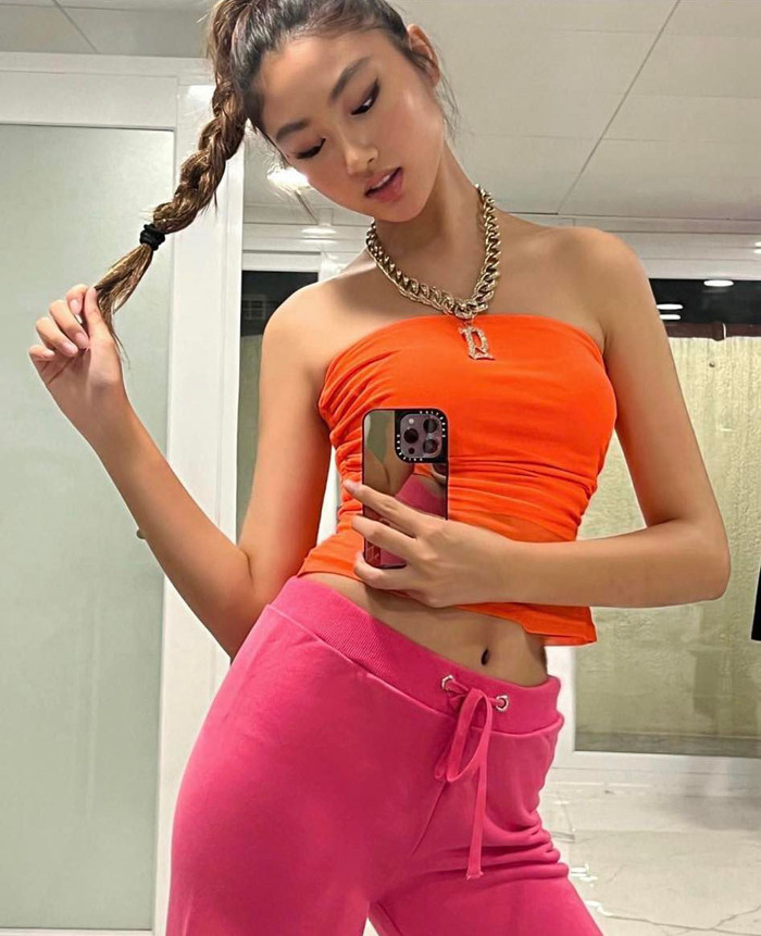 Kiểu quần lưng chun thoải mái được nàng mẫu sắm đa dạng màu sắc. Lần này, Ella phối cùng mẫu áo ống nhuộm tông cam bắt mắt. Tăng thêm sự sành điệu, cô đeo dây chuyền mắt xích bản lớn đính kí tự.