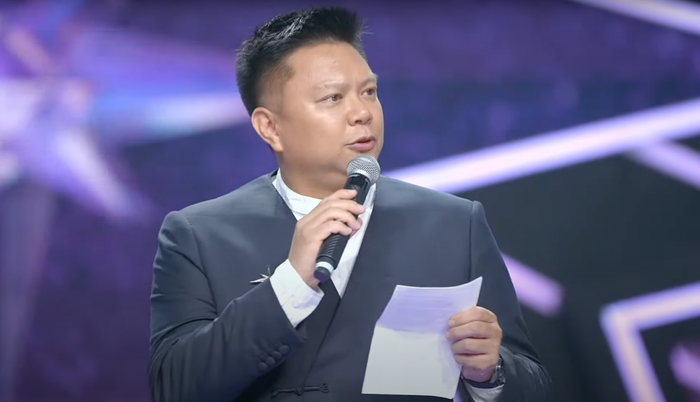 Chủ tịch Miss Universe Vietnam cầm giấy để đọc phát biểu bằng tiếng Anh.