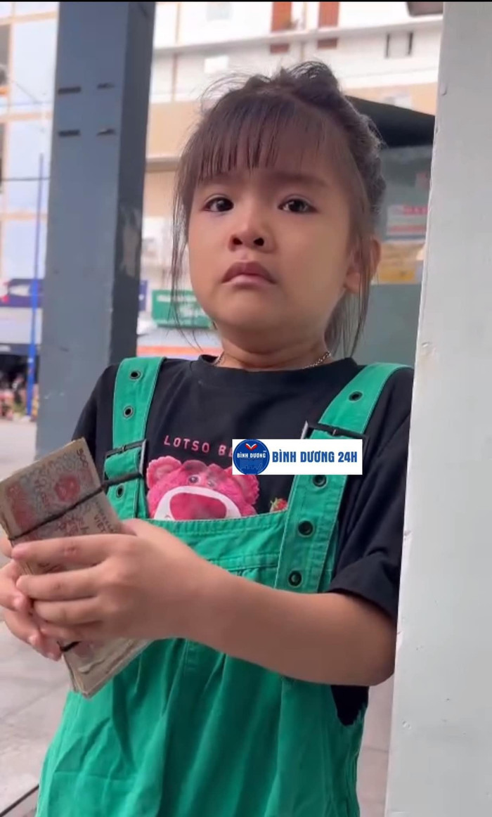 Bé gái dành dụm tiền quà vặt để ủng hộ bạn bè vùng bão lũ. Ảnh: Bình Dương 24h