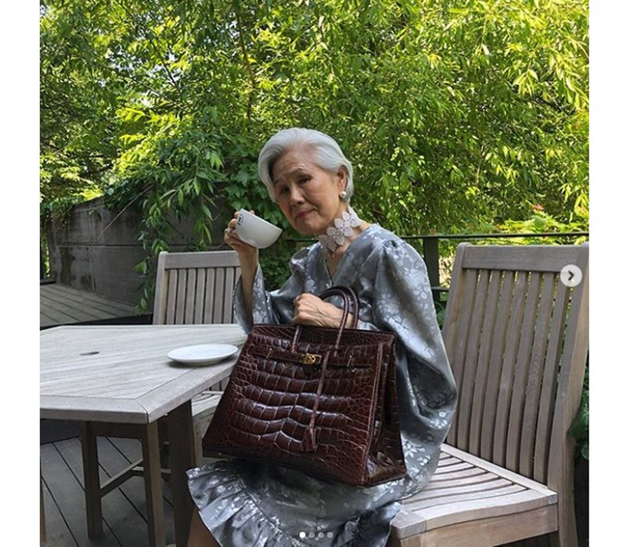 Bà Choi Soon-hwa luôn kỹ tính trong việc lựa chọn phụ kiện phù hợp cho layout. Trong ảnh, 'quý bà phong cách' đeo một chiếc túi size lớn của dòng Hermes Birkin, đi kèm với vòng cổ hình hoa 'ton-sur-ton' với chiếc đầm dáng chữ A có nhún bèo ở phần đuôi. 