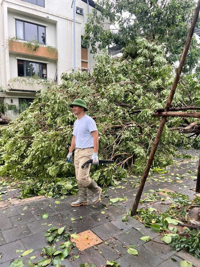 Ngay sau bão số 3, NSND Xuân Bắc cùng 2 con trai phụ giúp dọn dẹp cây ngã đổ trong khu phố.