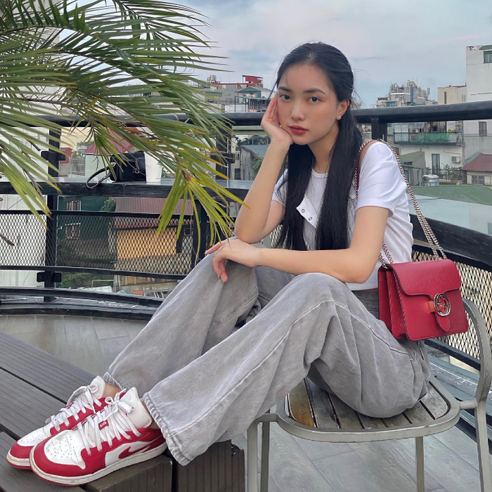 Vợ Hà Đức Chinh sở hữu thêm một mẫu túi khác đến từ thương hiệu tương tự mang tông màu đỏ đô nổi bật. Thiết kế này cũng theo form dáng hình chữ nhật, nắp gập và có dây đeo dài. Nó được bán với mức giá hơn 30 triệu đồng.