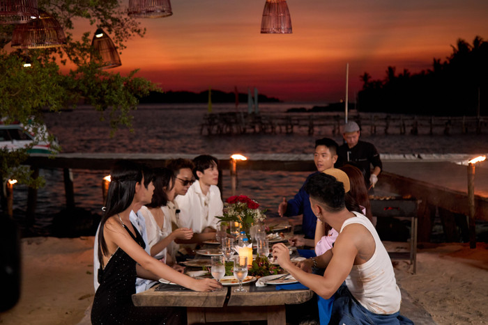 Người chơi dùng bữa tối dưới hoàng hôn tại bãi biển.
