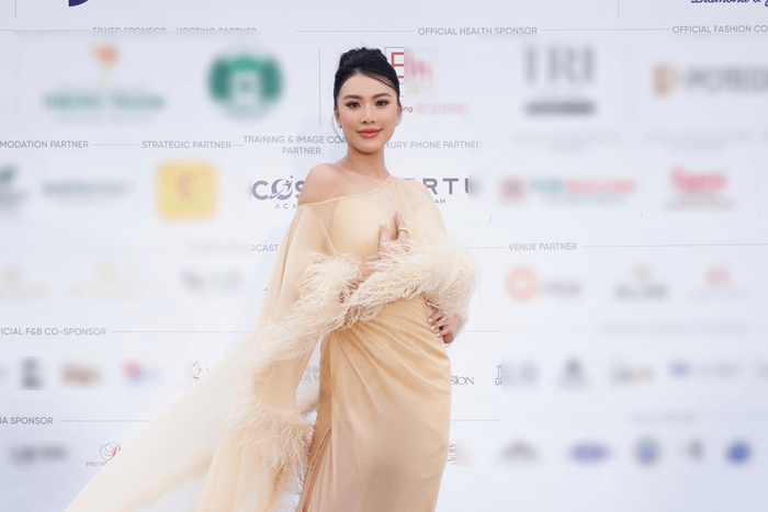 Á hậu - Giám khảo Miss Cosmo 2024 Kim Duyên chọn mẫu váy kín đáo có tông màu be ngọt ngào. Toàn bộ chiếc váy được bằng vải lụa mềm mại có thiết kế vai xéo kết hợp cùng chi tiết lông vũ uốn lượn trên thân áo. 