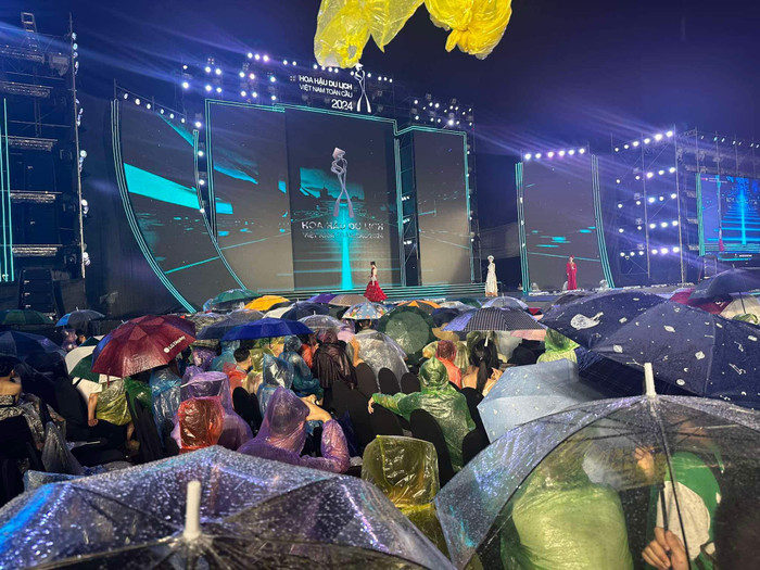 Cơn mưa nặng hạt khiến khán giả bật dù xem hoa hậu. 