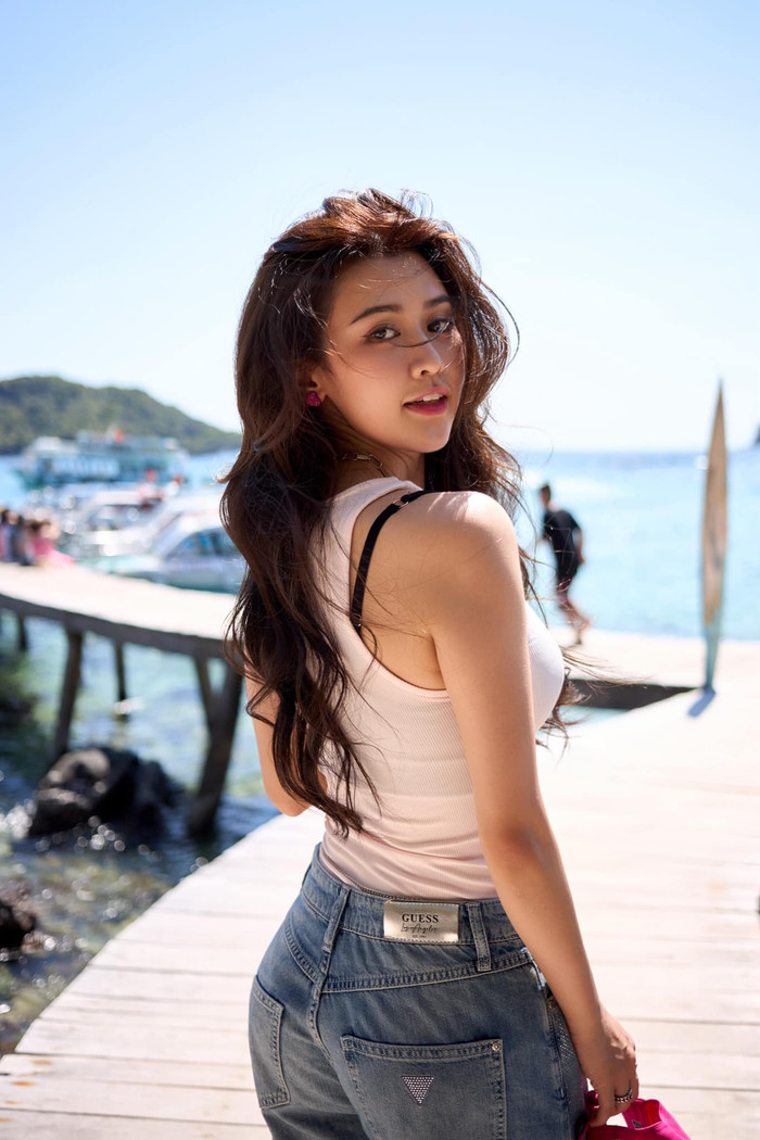 Quyên Qui mặc kiểu áo thun tank-top trắng để khoe trọn bờ vai thanh mảnh, đi kèm quần jeans rộng rãi đem lại cảm giác trẻ trung. Cô nàng đeo thêm phụ kiện gồm nhẫn, dây chuyền bạc kèm theo nón hồng để che chắn ánh nắng.  