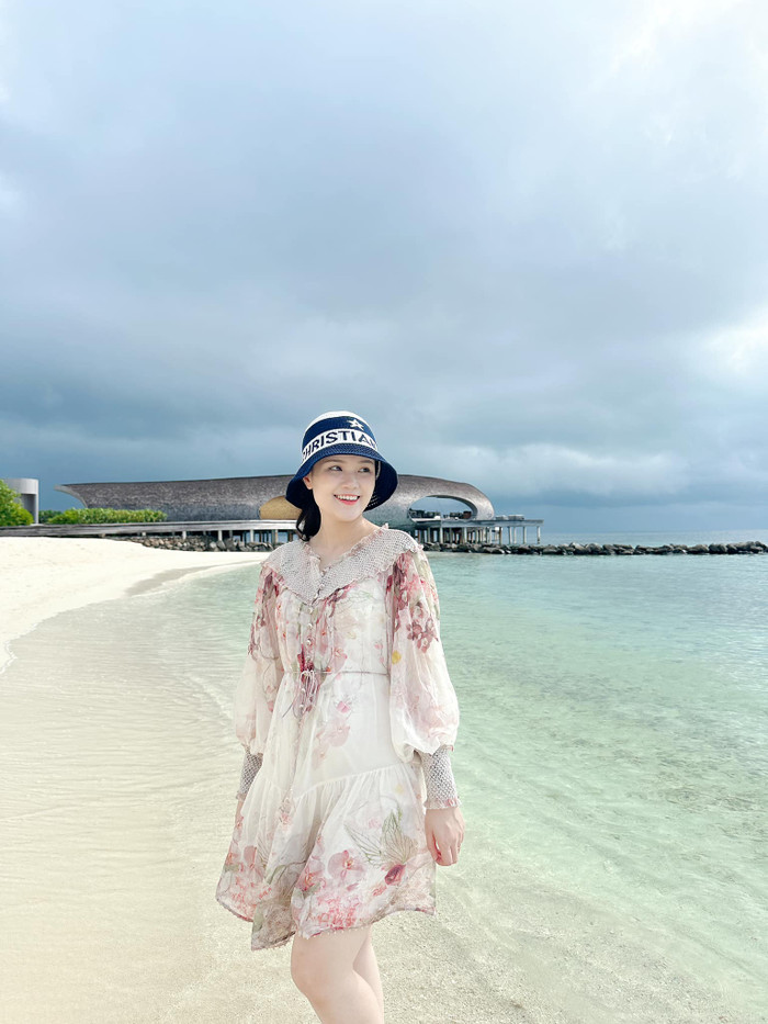 Trong một chuyến du lịch biển, vợ Duy Mạnh diện mẫu váy ngắn, form dáng rộng rãi, được tạo điểm nhấn với hoạ tiết hoa và mang tông màu hồng chủ đạo. Thiết kế này giúp cô tôn lên sự nữ tính, mềm mại. Quỳnh Anh phối cùng chiếc nón bucket đến từ Dior - 'nhà mốt' có Jisoo (BLACKPINK) làm đại sứ thương hiệu. Món phụ kiện này có giá bán hơn 20 triệu đồng. Tuy nhiên, sự kết hợp giữa chiếc nón bucket và đầm hoa của vợ Duy Mạnh bị đánh giá lạc quẻ, thiếu ăn nhập. Món phụ kiện này toát lên sự năng động, cá tính, đi ngược hoàn toàn với tinh thần của trang phục.