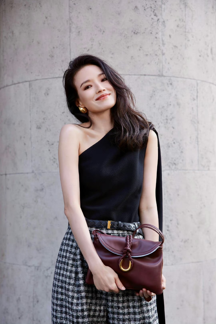 Thư Kỳ cũng là nhân vật diện áo lệch áo trong tuần này. Nữ diễn viên thu hút trọn ống kính với diện mạo trẻ trung, năng động. Bộ cánh được phối giữa áo lệch vai đen màu đen trơn cùng quần sọc caro và thắt lưng khóa vàng. Cả hai items trên dưới của Thư Kỳ đều thuộc danh sách thịnh hành trong xu hướng hiện nay. Để hoàn thiện layout, cô đeo hoa tay vàng bản to cùng túi cầm tay đỏ đô. 