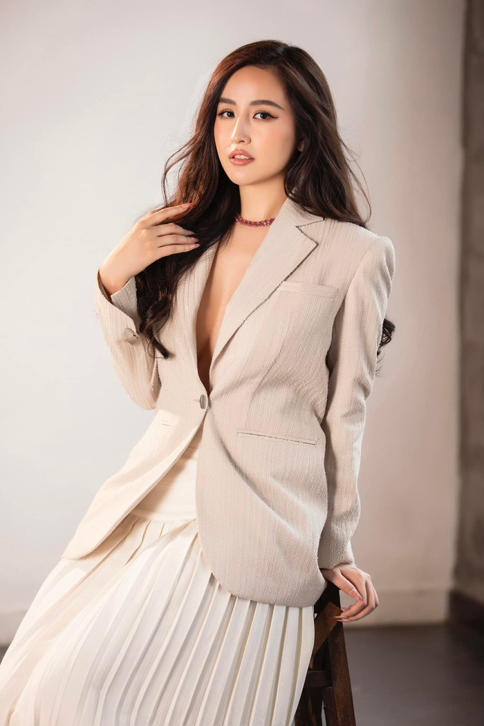Trong một bộ hình khác, Mai Phương Thúy lại kết hợp mẫu áo blazer màu be với chân váy xoè tạo cảm giác mềm mại. Nàng hậu không diện nội y bên trong, để lộ vòng một đẫy đà, quyến rũ tột độ.