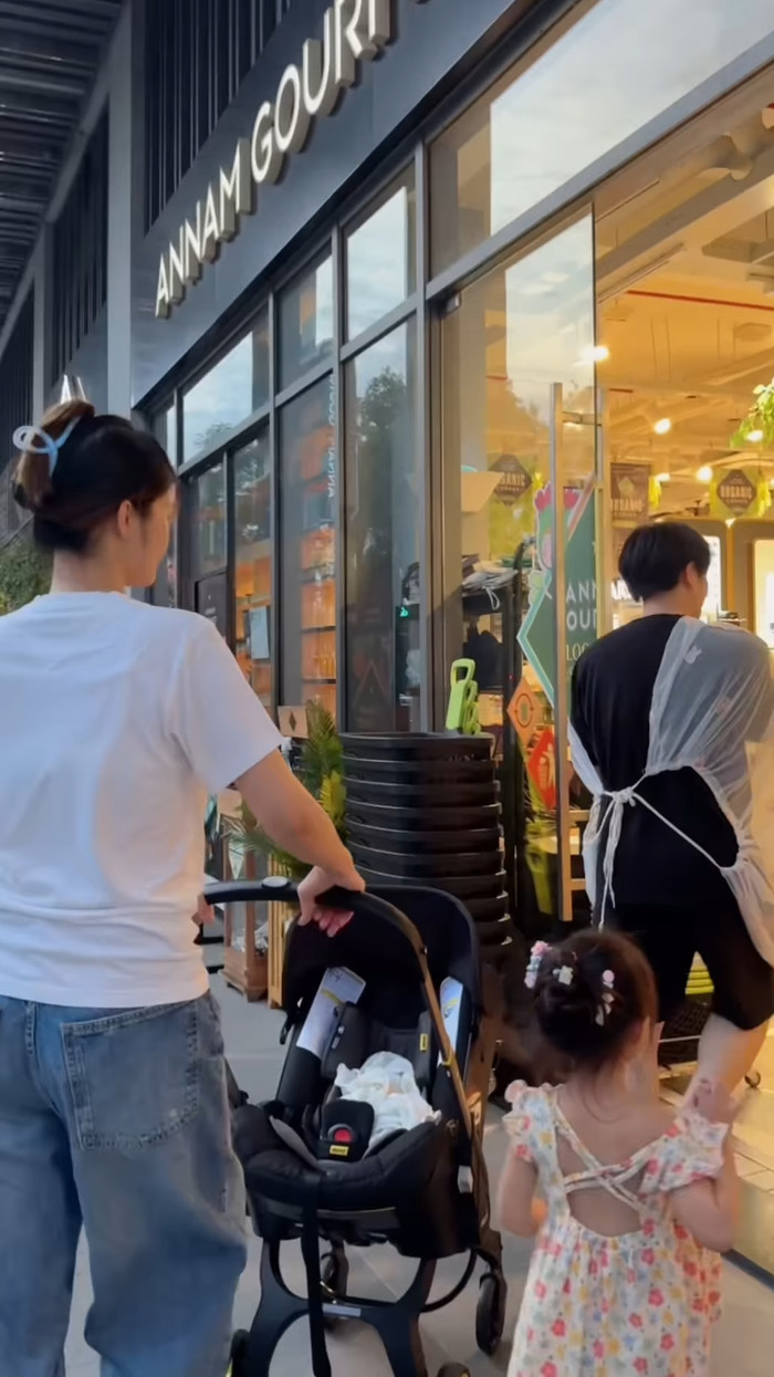 Khi vào đến siêu thị mua sắm, Đông Nhi trông con gái lớn, Ông Cao Thắng dùng vải thưa khi bế con gái út trên tay. Ảnh: Chụp màn hình