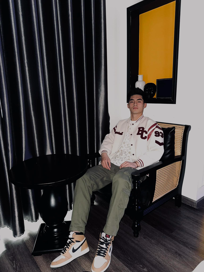 Về phần phong cách, Trần Trung Kiên ăn mặc khá thoải mái nhưng vẫn tạo được nét mạnh mẽ, cá tính. Trong ảnh, anh phối áo thun trắng có logo hologram kết hợp áo khoác bomber bóng chày, quần túi hộp cùng một đôi sneaker cổ cao. 
