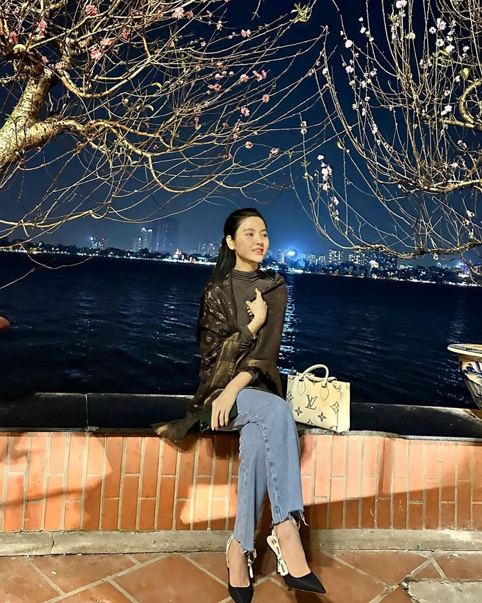 Một lần dạo phố đêm, Chu Thanh Huyền còn mang mẫu túi hình chữ nhật, mang tông màu trắng chủ đạo và được tạo điểm nhấn bằng hoạ tiết monogram. Thiết kế này của 'nhà mốt' đến từ Pháp, có mức giá khoảng 85 triệu đồng. Không những vậy, vợ Quang Hải còn kết hợp cùng mẫu khăn lụa màu đen bóng, trong cùng thương hiệu đó, được bán với mức giá 18 triệu đồng. Tính sương sương, Chu Thanh Huyền đã 'dát' hơn 100 triệu đồng xuống phố.