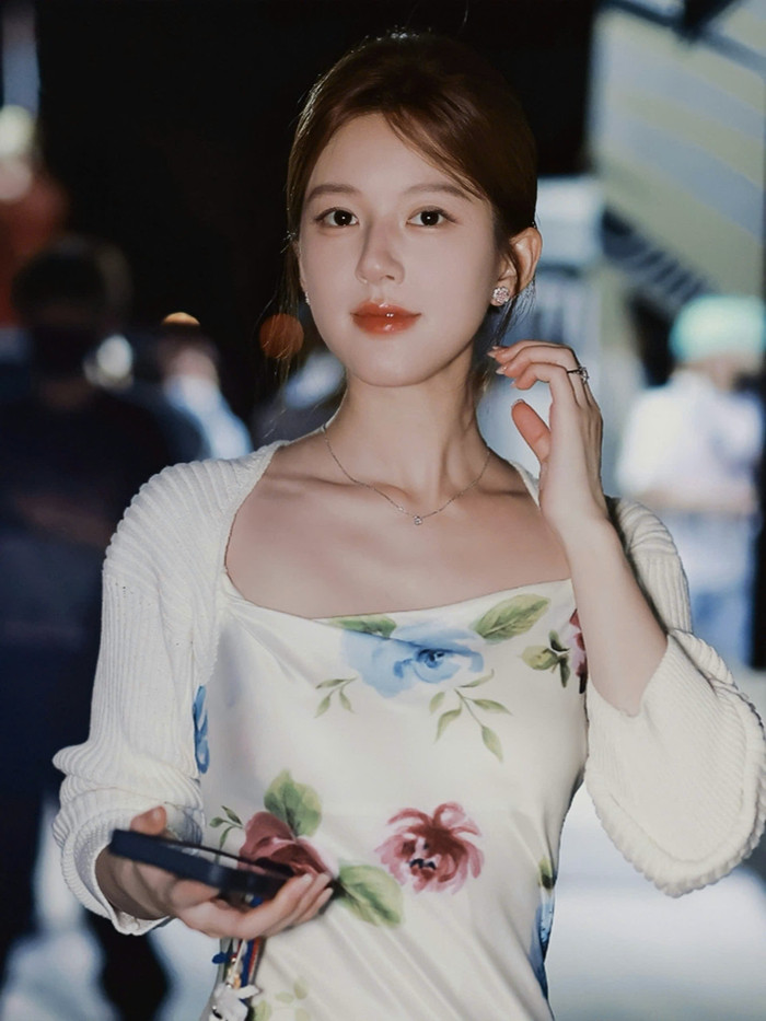 Sự kết đôi với mẫu mã áo khoác dệt kim tiếp tục được người đẹp sinh năm 1998 hưởng ứng.  Người đẹp xuống phố đầy quý phái trong bộ cánh hai dây sợi mảnh tô điểm hình ảnh chồi non và hoa đương mùa nở rộ. Phần cổ thuyền khéo léo trong thiết kế Rouje kết hợp khoác tay dài Matin Kim giúp tôn lên đáng kể khung xương quai xanh thanh mảnh của người mặc.  