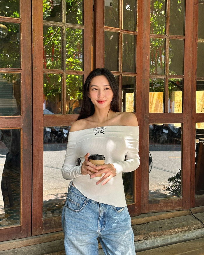 Những ngày thưởng lãm nội thành xứ Huế, Hoa hậu Thùy Tiên ưu ái xuống phố với các items có độ thoáng khí cao. Phối cùng quần jeans ống rộng bạc màu, cô chọn mẫu áo bẹt vai phong cách tiểu thư dệt có họa tiết nơ trung tâm. Theo tìm hiểu, chiếc midori top được nhà mốt bán ra khoảng 250 nghìn đồng.